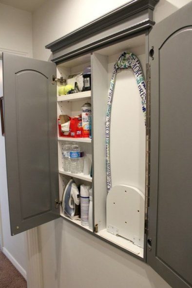 built-in ironing board in the closet with shelves
