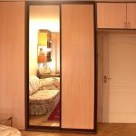 Fitted wardrobes surround the entrance door