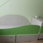 Children's bed with a high protective side