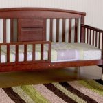 postel s dřevěnými stěnami
