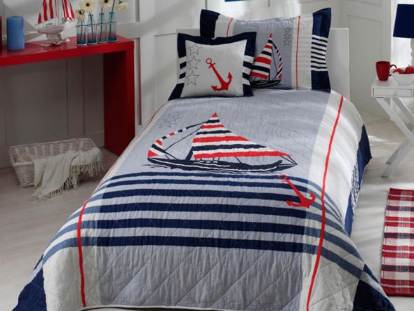 Baby bedspread on the bed for the boys in the marine style