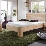 medinė lova miegamajame