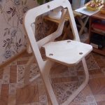 składane krzesło wykonane ze sklejki we wnętrzu