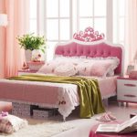 Rožinė lova miegamojoje merginos nuotraukoje