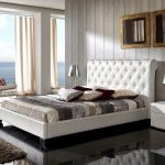 السرير والكراسي في غرفة النوم مصنوعة من الجلد الأبيض.