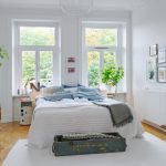 White bedroom with headboard to two windows