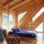 Trä säng på vinden våningen för ett rustikt sovrum