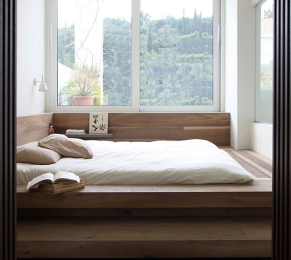 Wooden bed-podium at the window