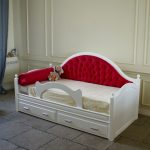 Baby bed with a red soft back
