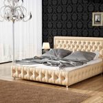 Elegant bed with soft headboard in beige tones