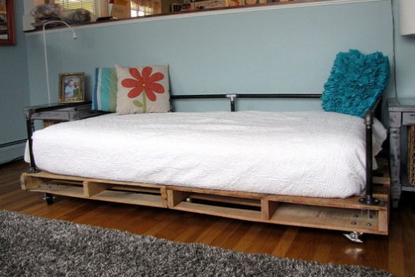Bed of wooden pallets and metal pipes