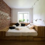Bed in a small room with a brick wall
