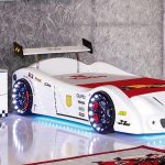 Bed in the form of a white race car in the interior of a teenager's room