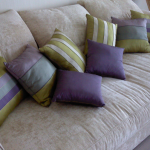 Bej renkli bir kanepe için küçük şeritli yastıklar