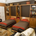 Vienvietės lovos, įmontuotos į spintą, gyvenamajame kambaryje