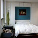 Garderob med inbyggd säng i inredningen av ett litet sovrum
