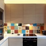 Mozaik karolar ve aydınlatılmış çalışma yüzeyi ile şık bir mutfak