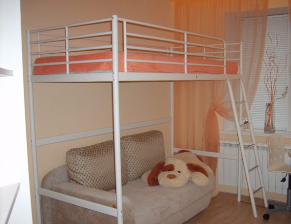 Bijeli metalni krevet u potkrovlju u unutrašnjosti prostorije