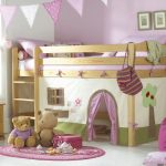 Łóżko dziecięce na poddaszu, położone w rogu małego pokoju dziecięcego
