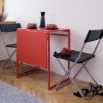 Red folding table and folding chairs for a small kitchen