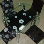 Round glass table at black chairs