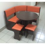 Pomarańczowy aneks kuchenny ze stołem i krzesłami