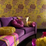 Purpurinės sofos ir geltonos spalvos tapetų derinys