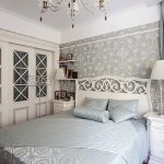 Valkoinen sänky, jossa on suuri avokätinen selkä ja kaapit lasiovilla Provencen tyyliin