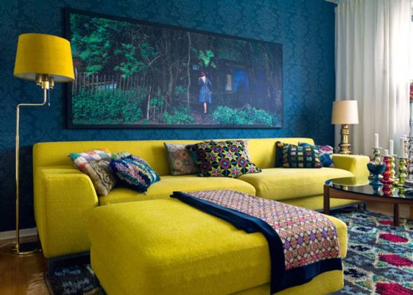 Jasna żółta sofa w pokoju niebieska