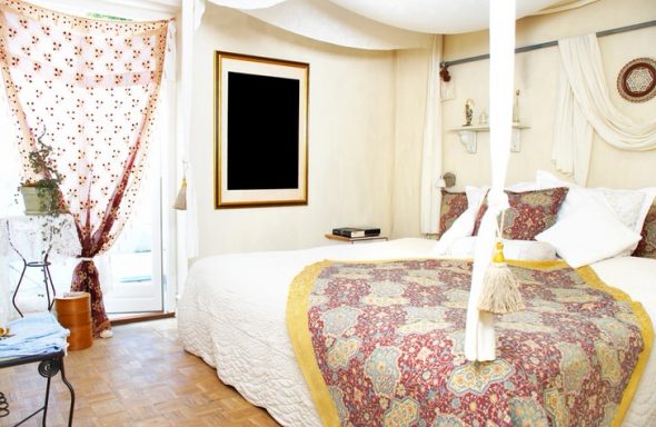Kreativna spavaća soba s bijelim namještajem i neobičnim dekorom.