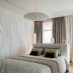 Monochrome bedroom na may puting kasangkapan at puti at beige na tela