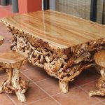 طاولة منحوتة ومقاعد مصنوعة من الخشب بأيديهم