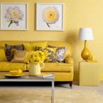 Jasna żółta sofa pod ścianami w kolorze piasku
