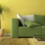 Green sofa sa background ng dilaw na dingding