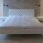 White floating bed with a soft back