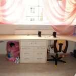 غرفة وردية للأطفال مع طاولات زاوية لطفلين