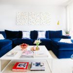 Niebieska welurowa sofa w białym pokoju