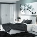 Bedroom in black and white with a corner wardrobe.