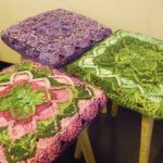 Knitted capes on stools