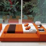 Malaking orange bed-podium para sa dalawa