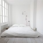 חדר לבן עם מיטה לבנה
