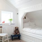 Bir niş içinde konforlu bir yatak ile beyaz yatak odası