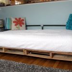 Do-it-yourself bed made of wooden pallets and metal pipes
