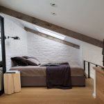 Sypialnia z ceglanymi ścianami na poddaszu
