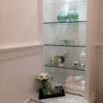 Glass shelves in the built-in niche in the bathroom