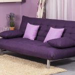 Violetinė sofa knyga svetainėje