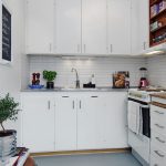 Snow-white kitchen furniture with wall cabinets up to the ceiling
