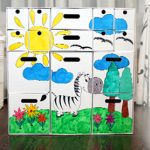 White cardboard chest of drawers with children's drawings