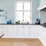 Large white kitchen with lower cabinets and decorative shelves