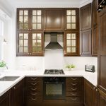 Wooden kitchen na may matangkad na cabinets sa dingding